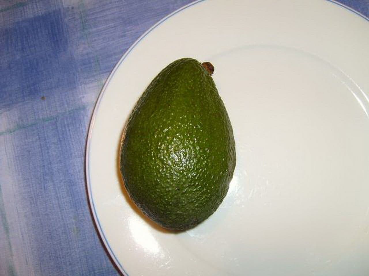 Whole avocado on a white plate